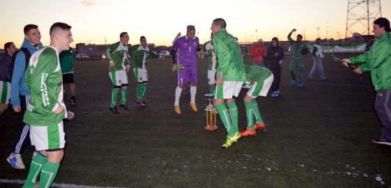 Los jugadores de Camioneros forman la ronda con el trofeo en el centro. El Verde se coronó en la cancha sintética.